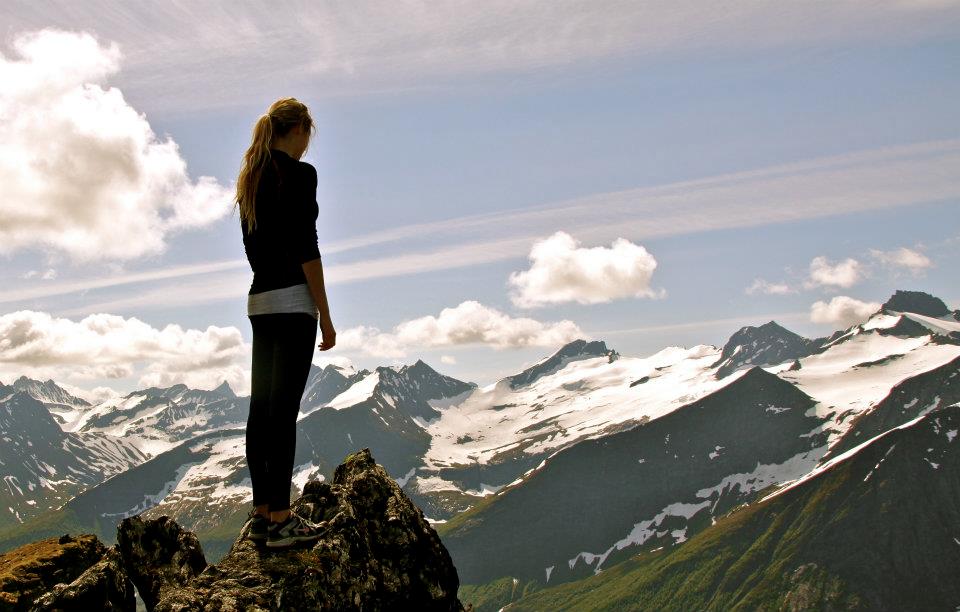 Ung kvinne på en fjelltopp