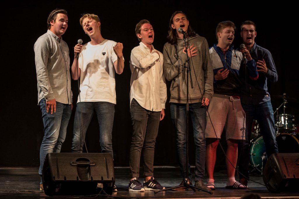Bilder av seks gutter som synger.