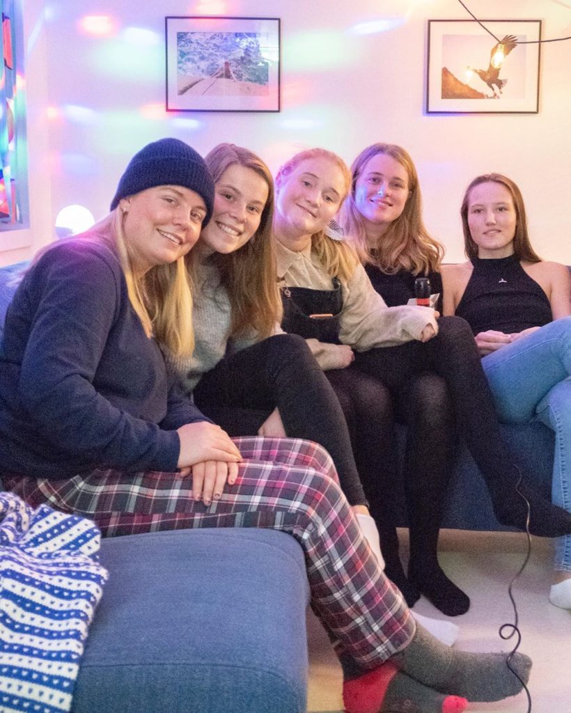 Elever i koseklær sitter i sofa