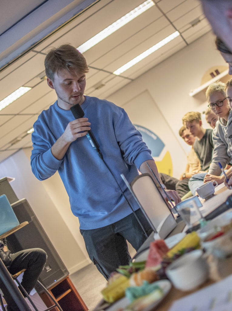 Martin Jønsrud viser frem modellen han og gruppa har laga av glassruta på Under, og hvordan det skal kunne rengjøres enklere enn det gjøres i dag. Bilde: Kristin Vold Kelly