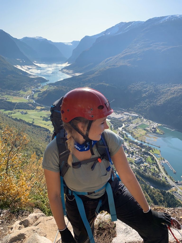 Fra Via Ferrata i Loen. Kristin med klatrehjelm foran utsikt