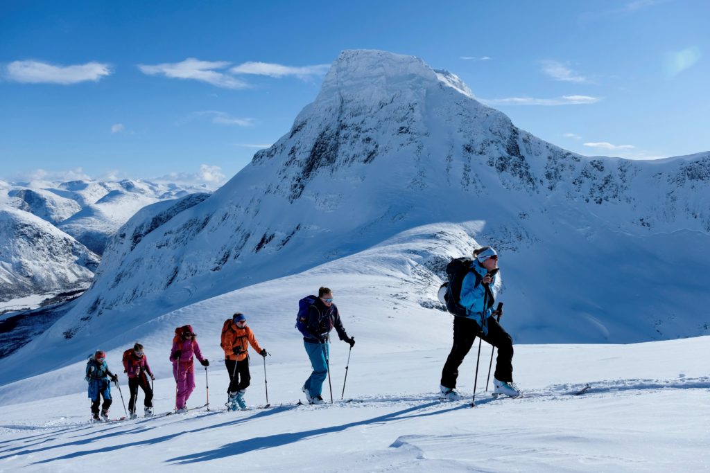 6 elever på ski, går i rekke oppover en bakke