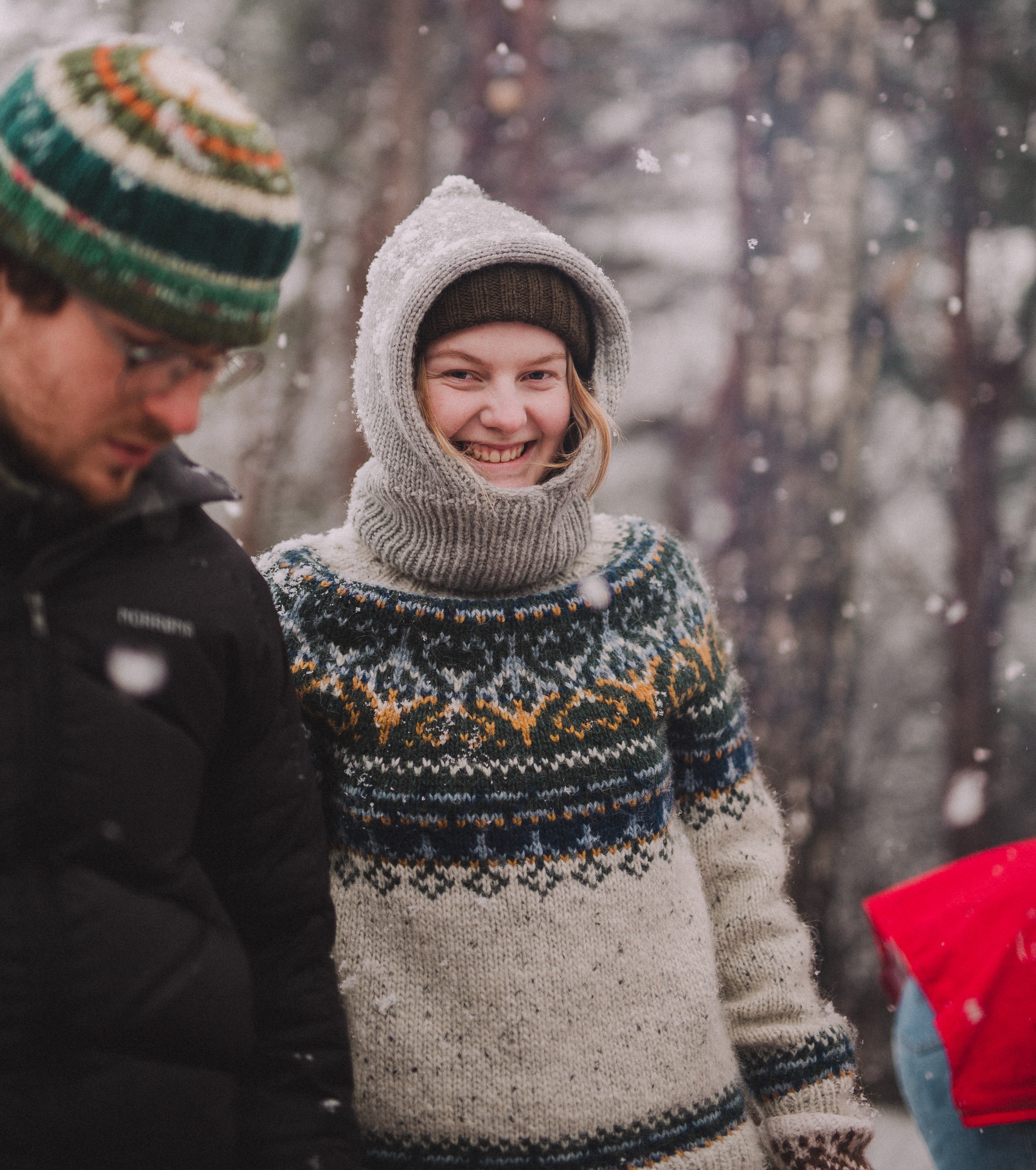 En jente med strikkegenser er ute mens det snør-