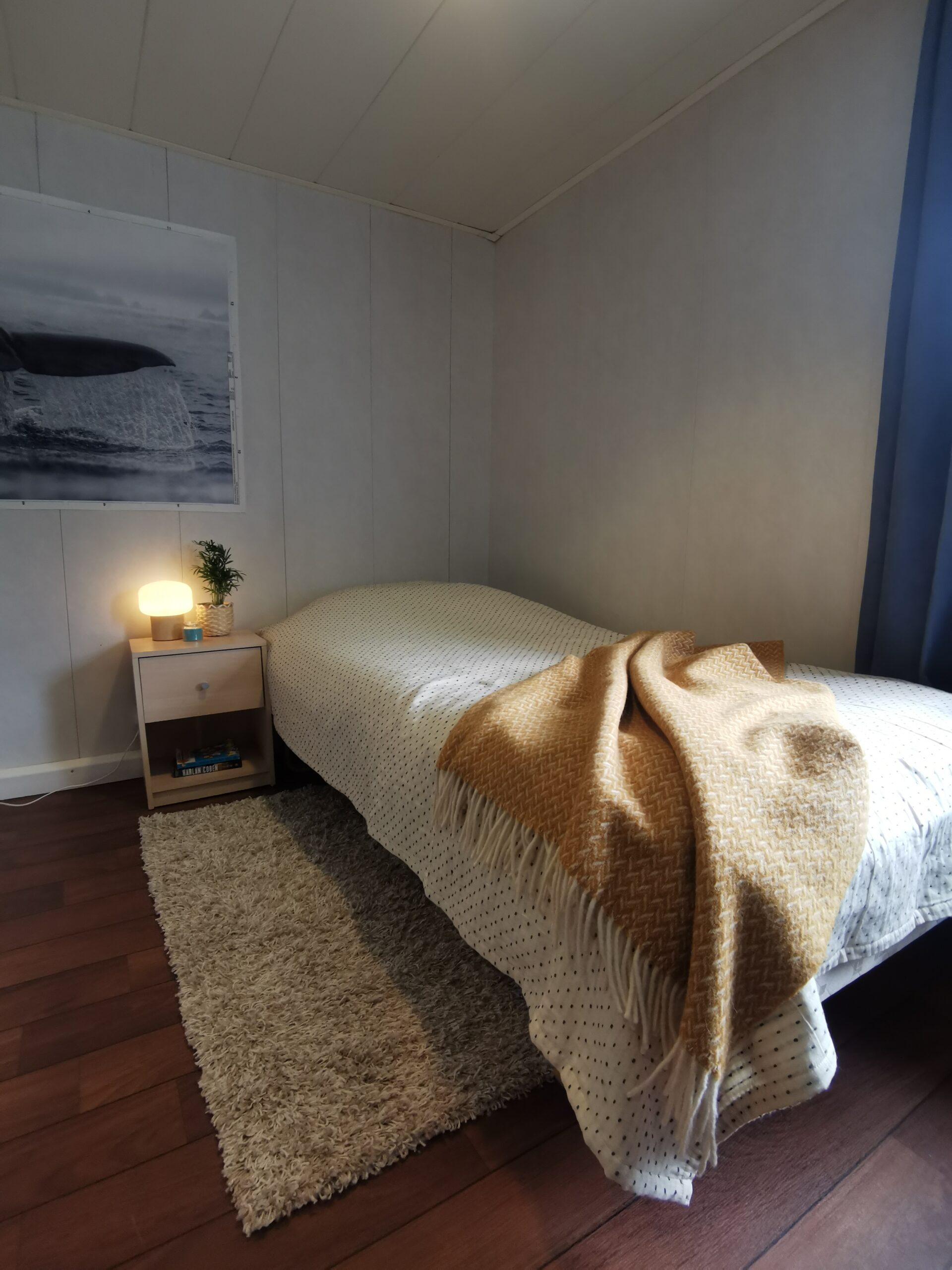 bilde av et rom med en seng, et bad, en lenestol, et bord og et skap