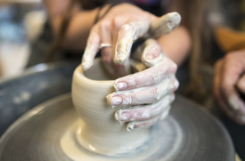 To hender som lager keramikk på dreieskive