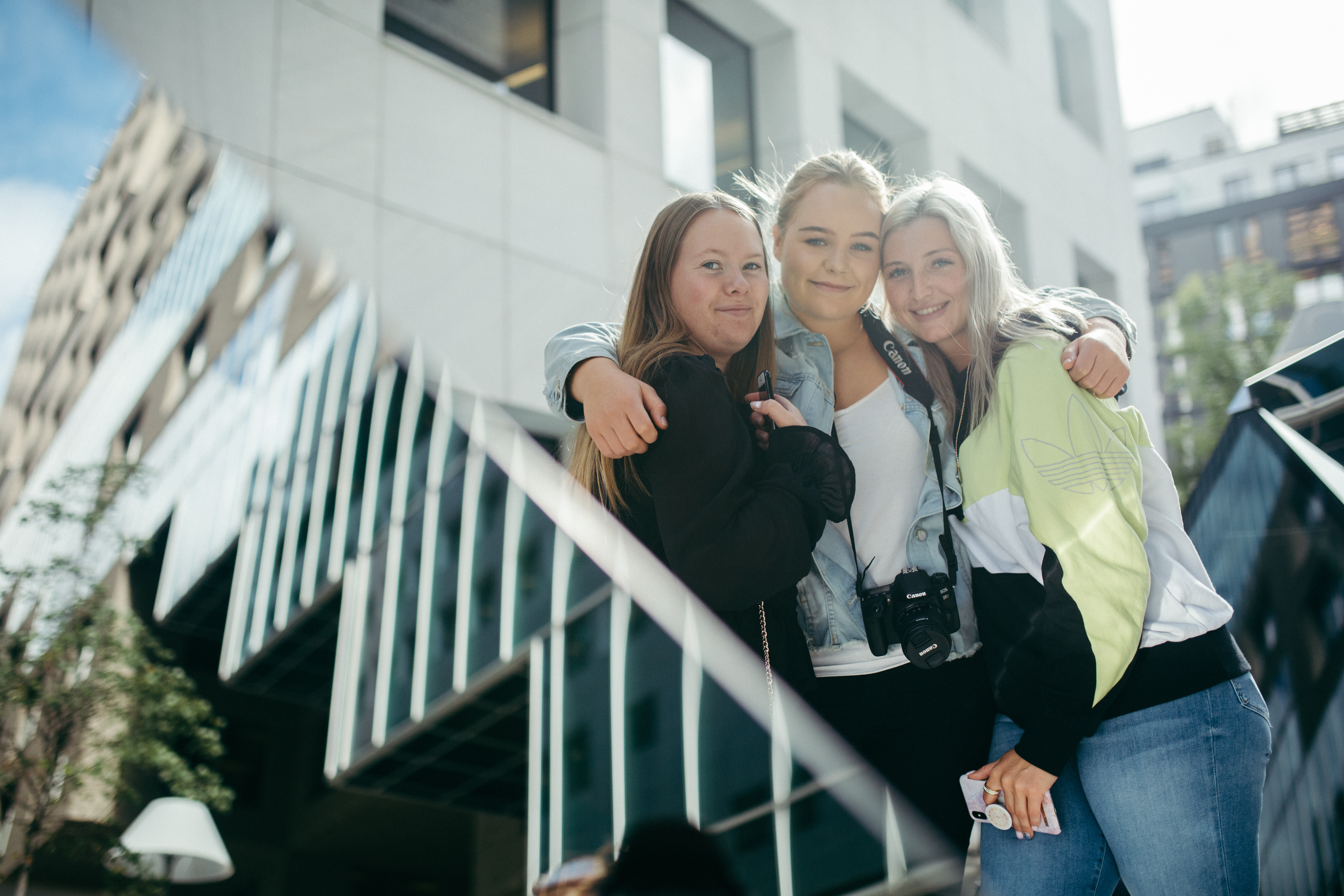 Tre elever foran bygninger i Oslo.