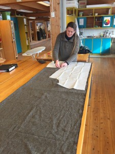 Linjelærer på Vikinglinjen, Linnea Bang-Madsen, klipper ut stoffstykker til et par bukser som er en kopi av bukser fra jernalderen