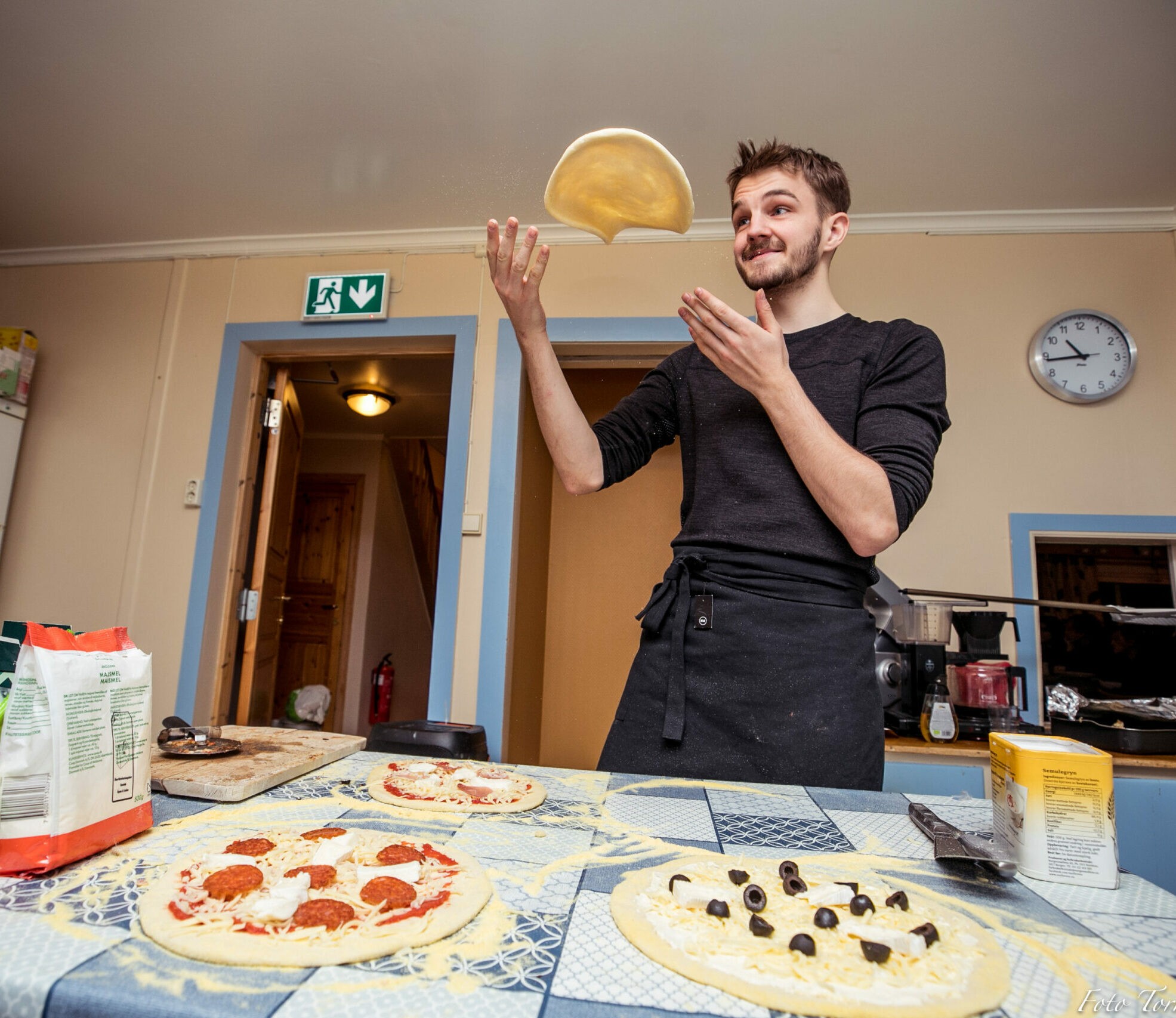 mann som lager pizzaer