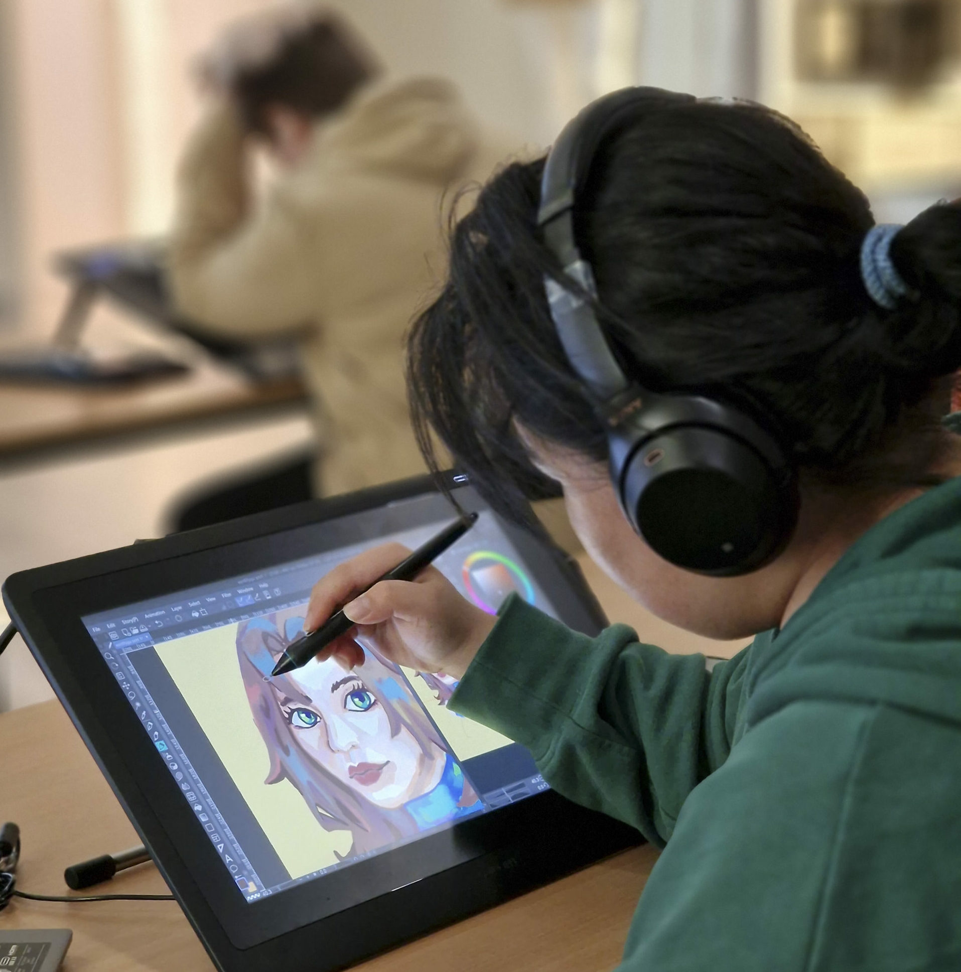 Person med høretelefoner tegner på et tegnebrett