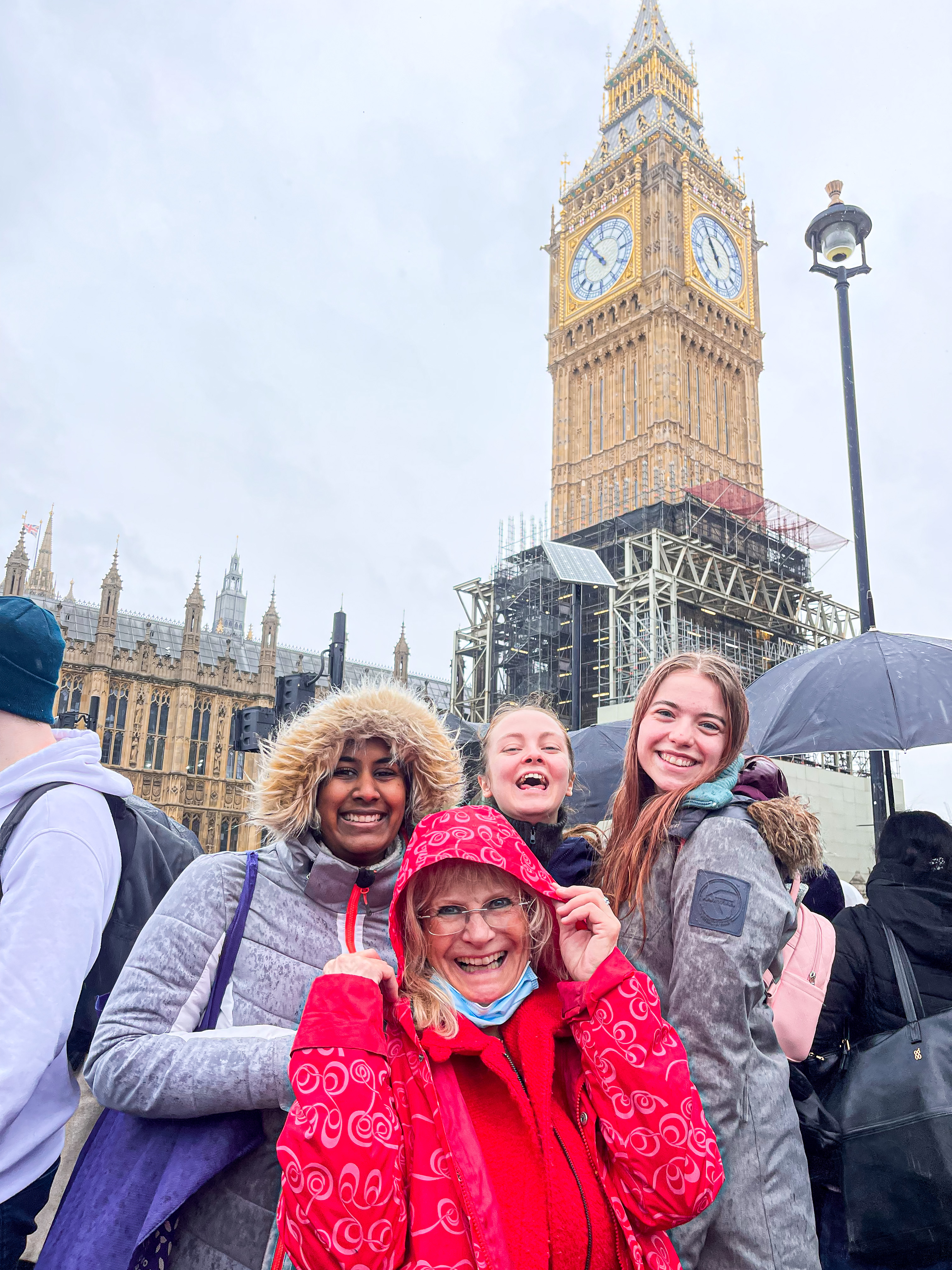 En lærer og tre elever foran BigBen i London. 