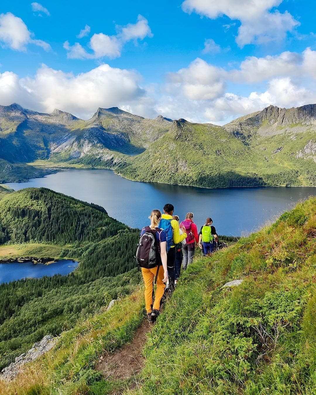 Elever fra Lofoten folkehøgskole går på smal sti med høye fjell i bakgrunnen