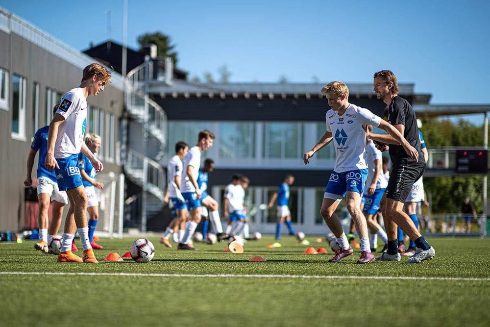 En gjeng fotballspillere på en kunstgressbane. 