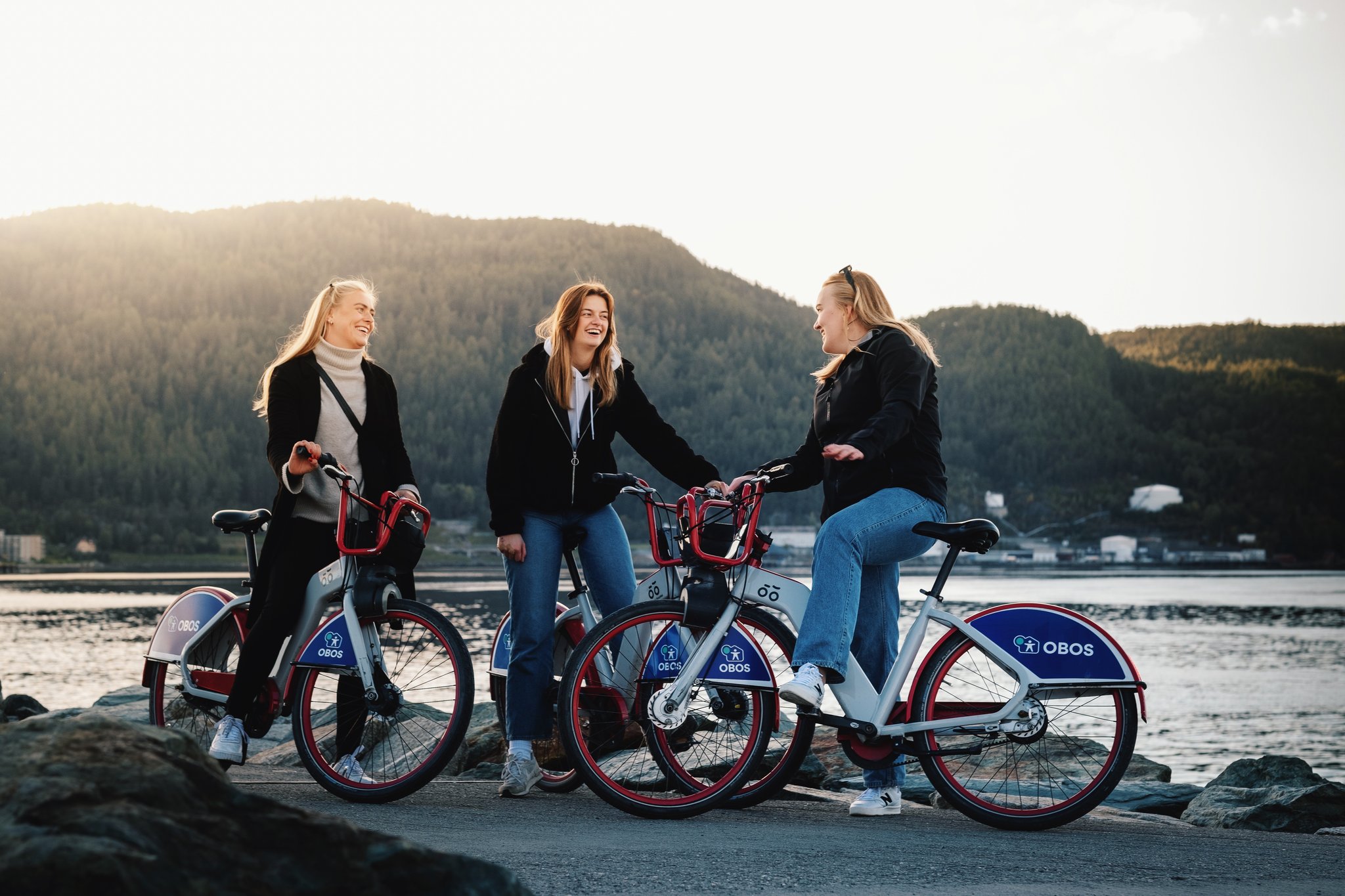 Tre jenter på bysykkel i Trondheim-by.