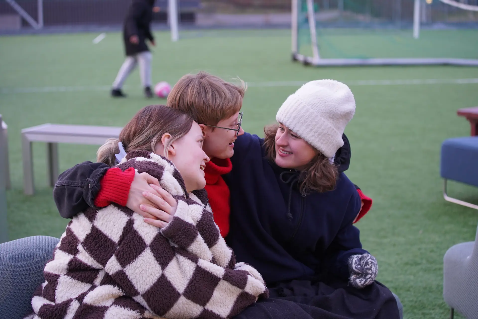 Tre unge jenter som sitter tett sammen