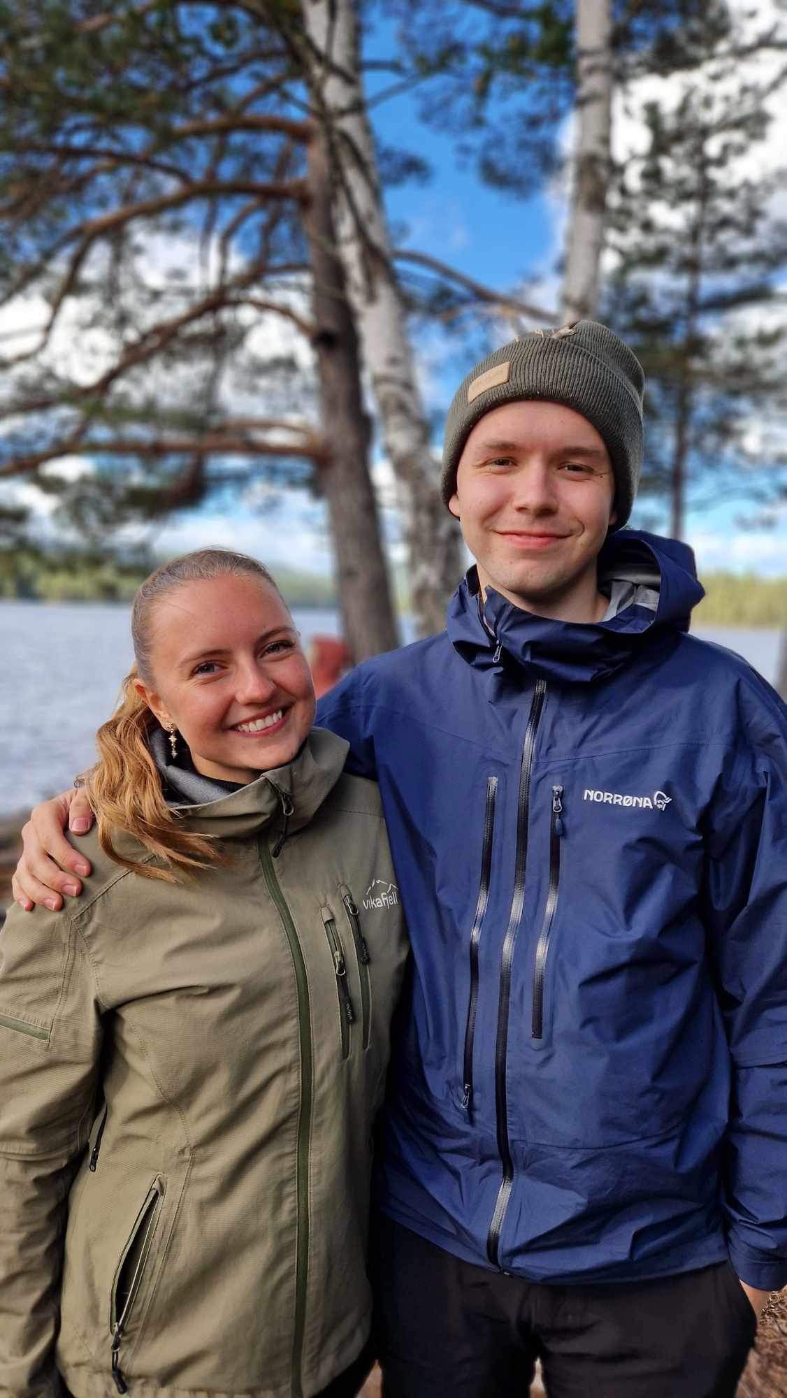 En ung jente og gutt som smiler i kamera