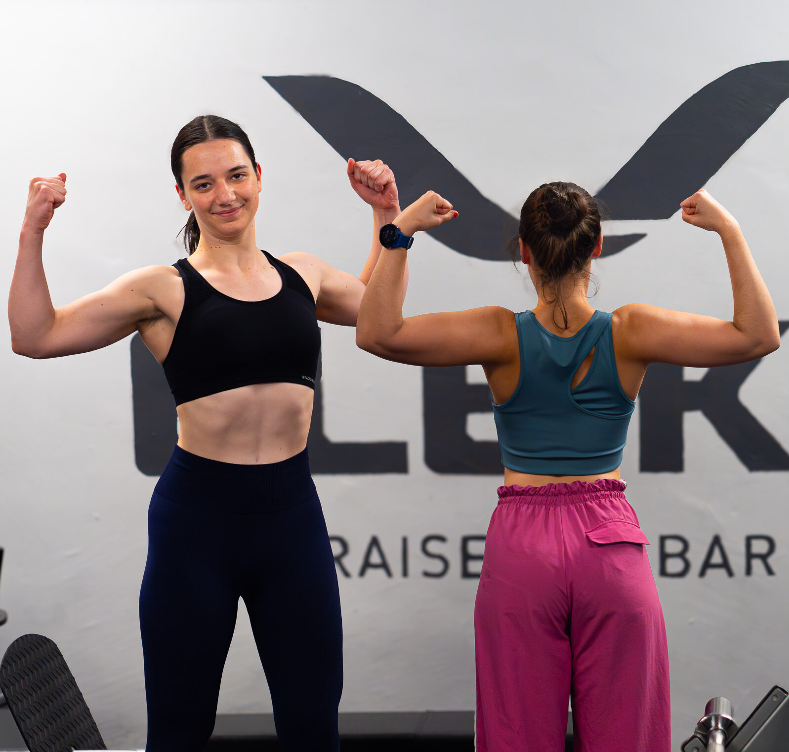 To unge kvinner som flekser muskler