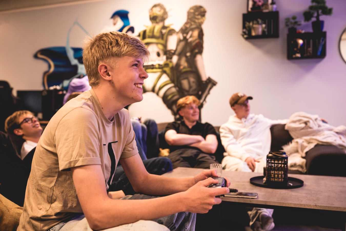 en gjeng unge gutter som spiller tv-spill og smiler