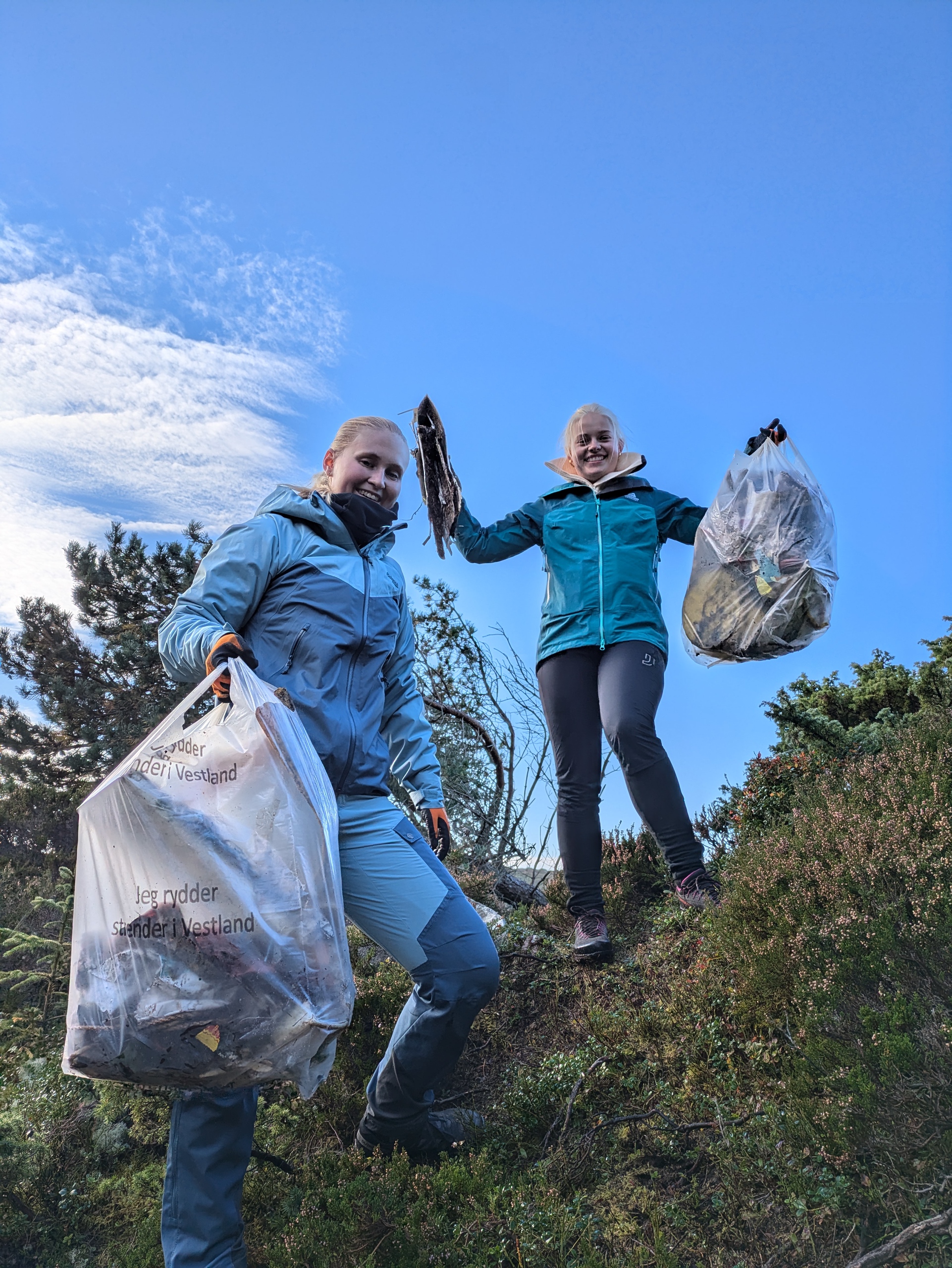 to unge kvinner som plukker søppel i fjæra