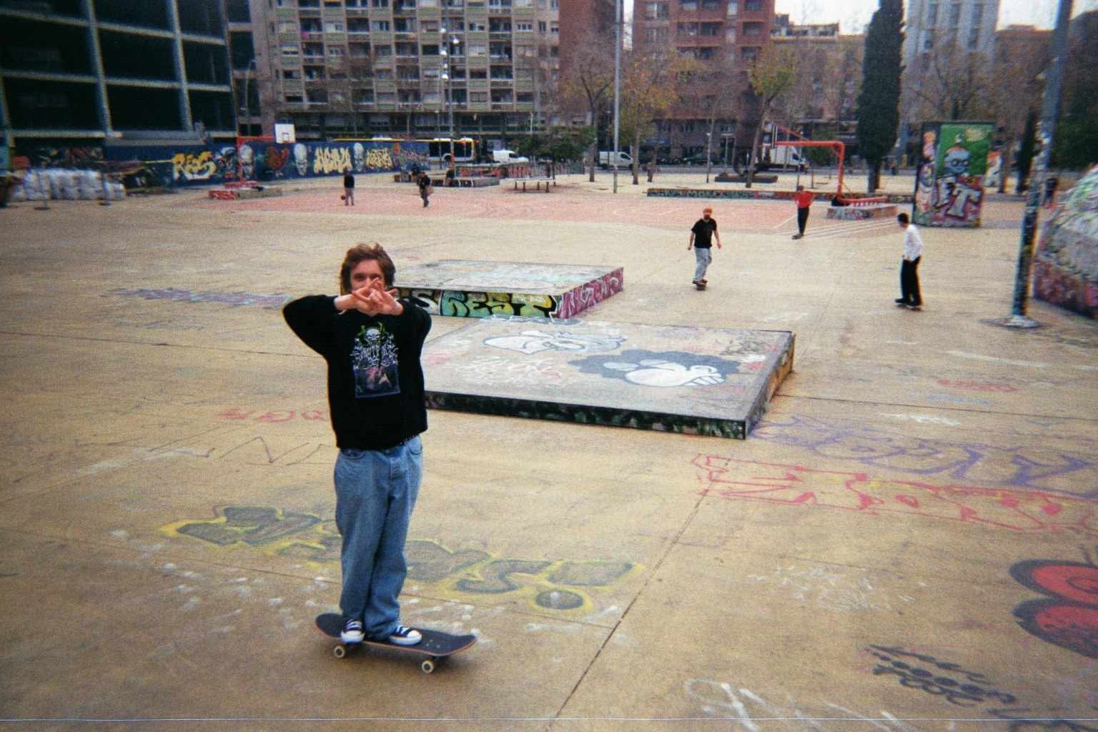 En gutt på skateboard ser i kamera