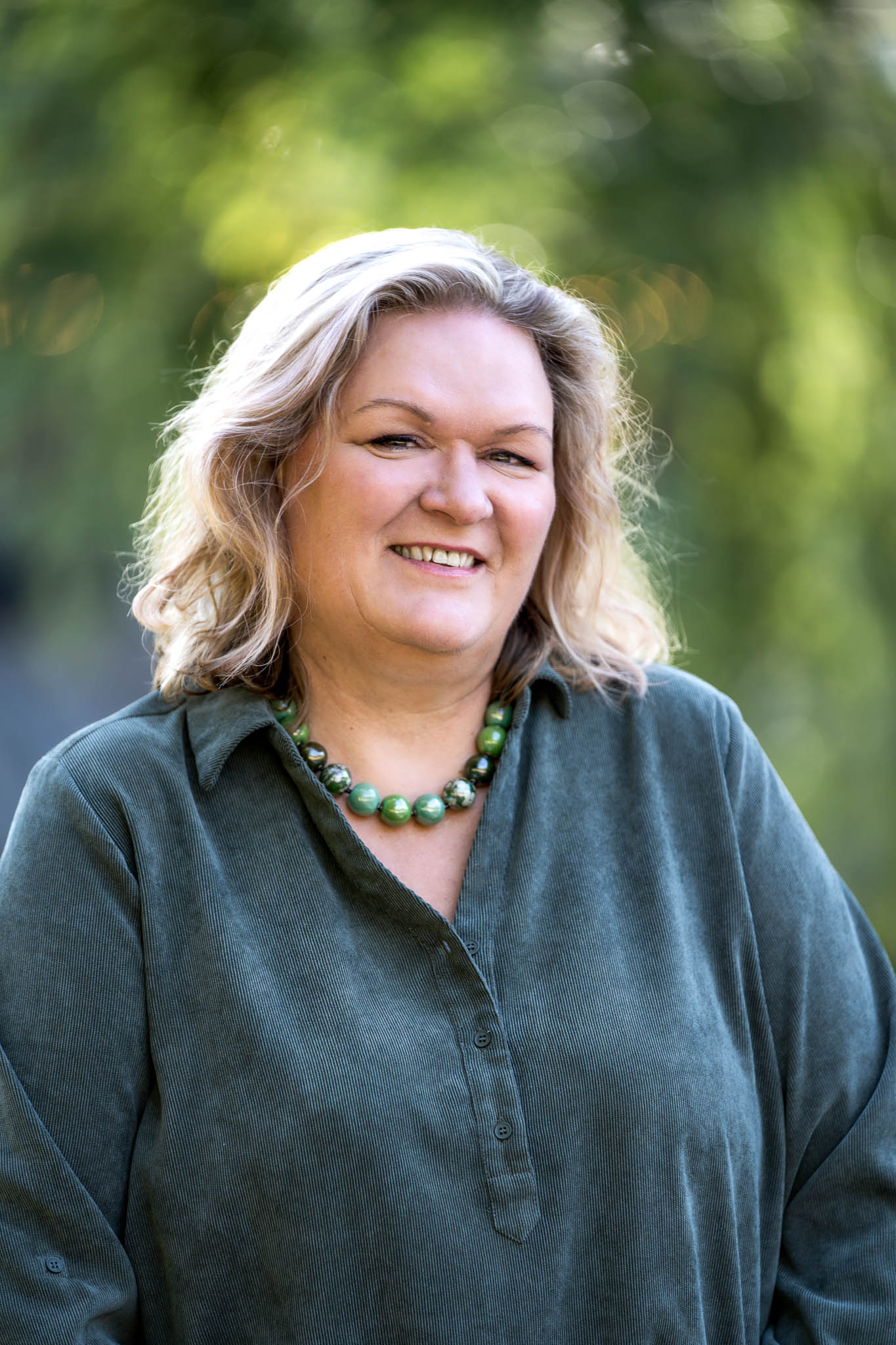 En lyshåret dame smiler i kamera