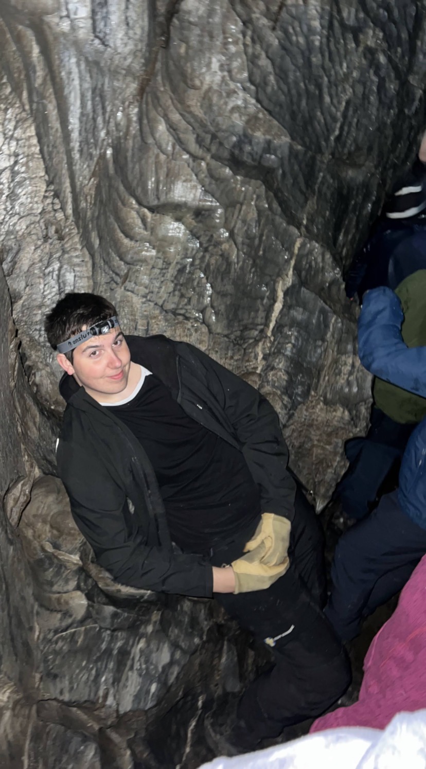 En gutt sitter inne i en hule