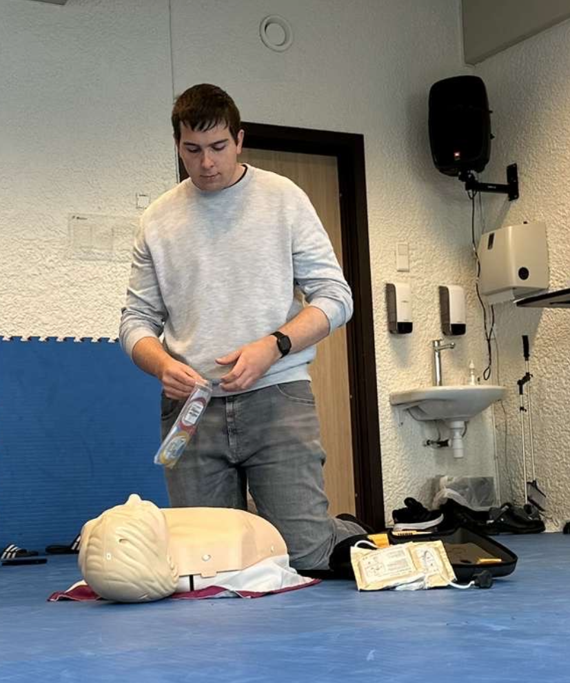 En gutt sitter med en førstehjelpsdukke