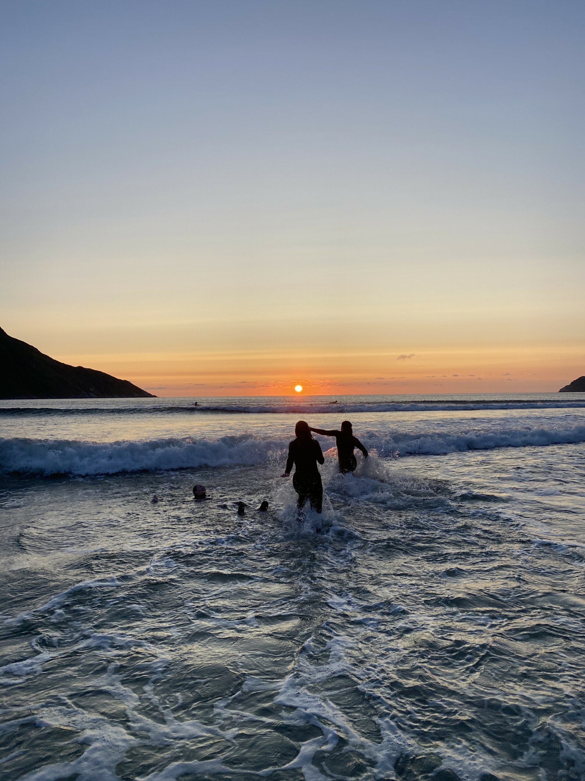 To løper ut i en solnedgang i sjøen