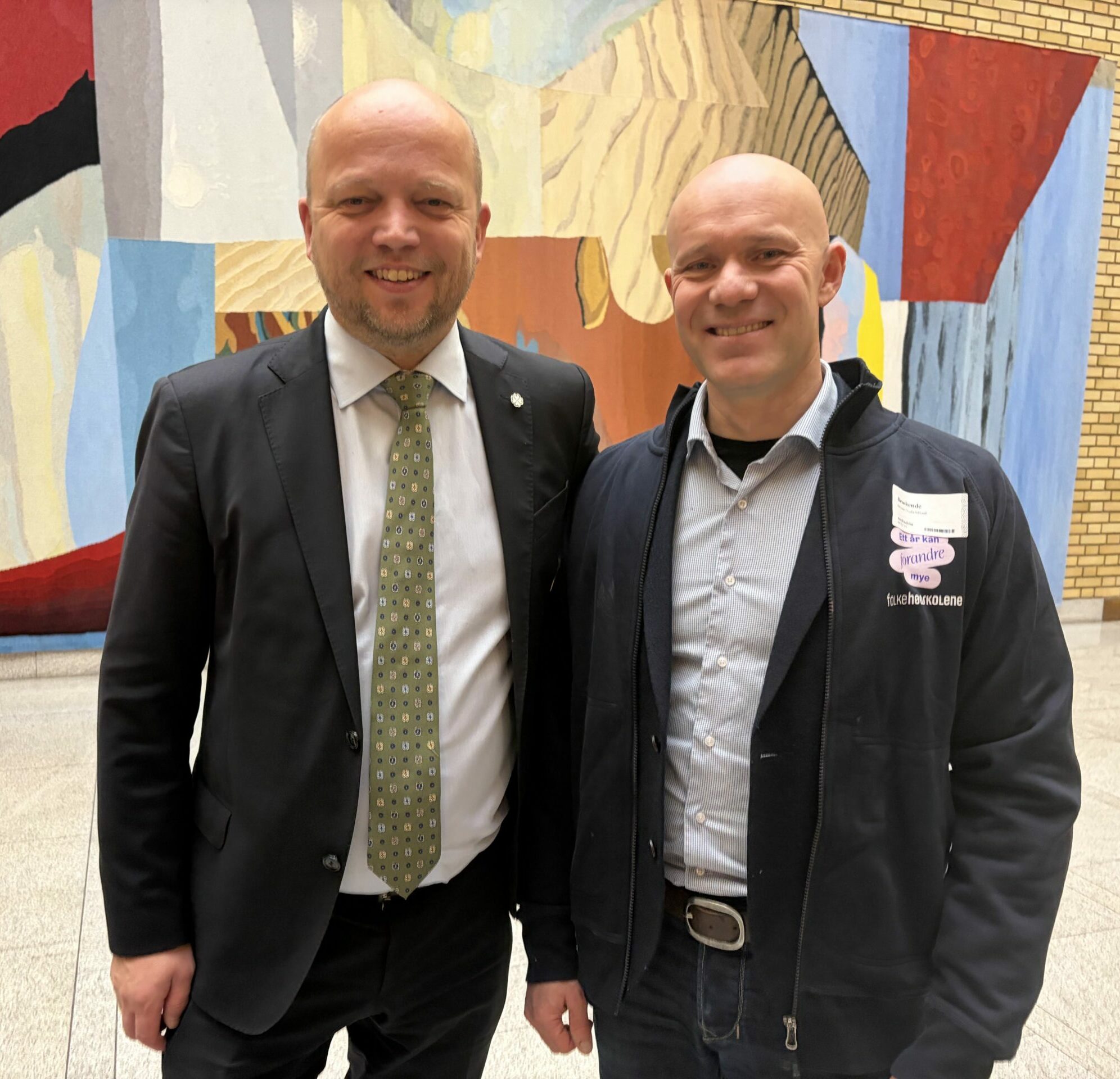 To menn smiler i kamera