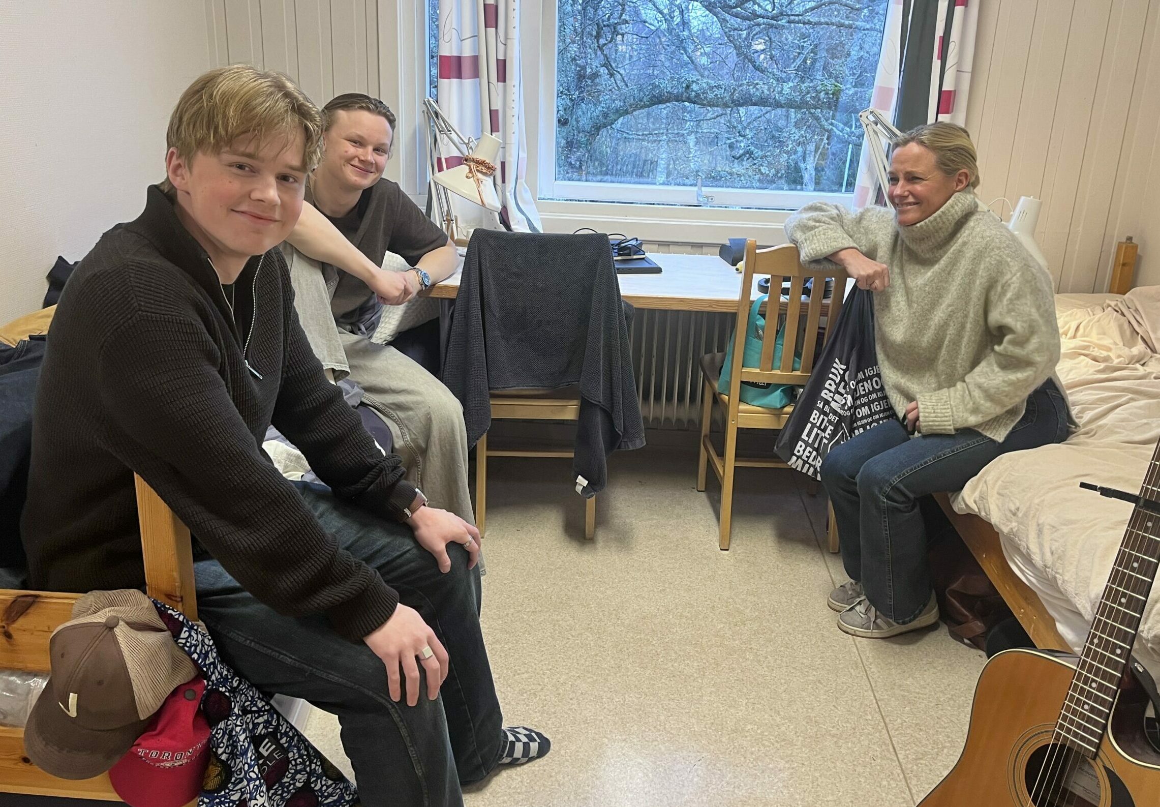 to unge menn og Solveig Kloppen som sitter inne på et internatrom