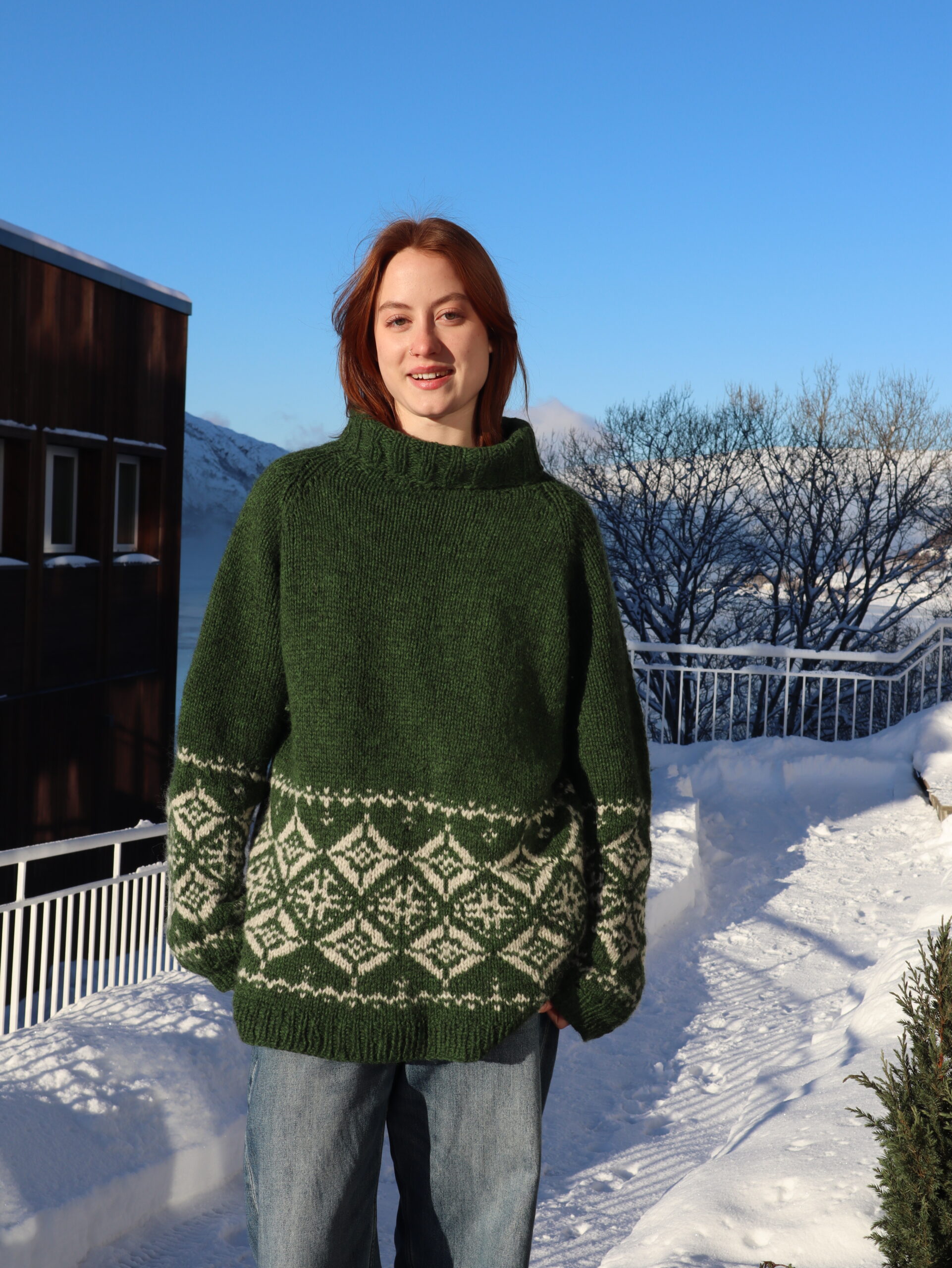 Jente i grønn strikkegenser, vinterlandskap.