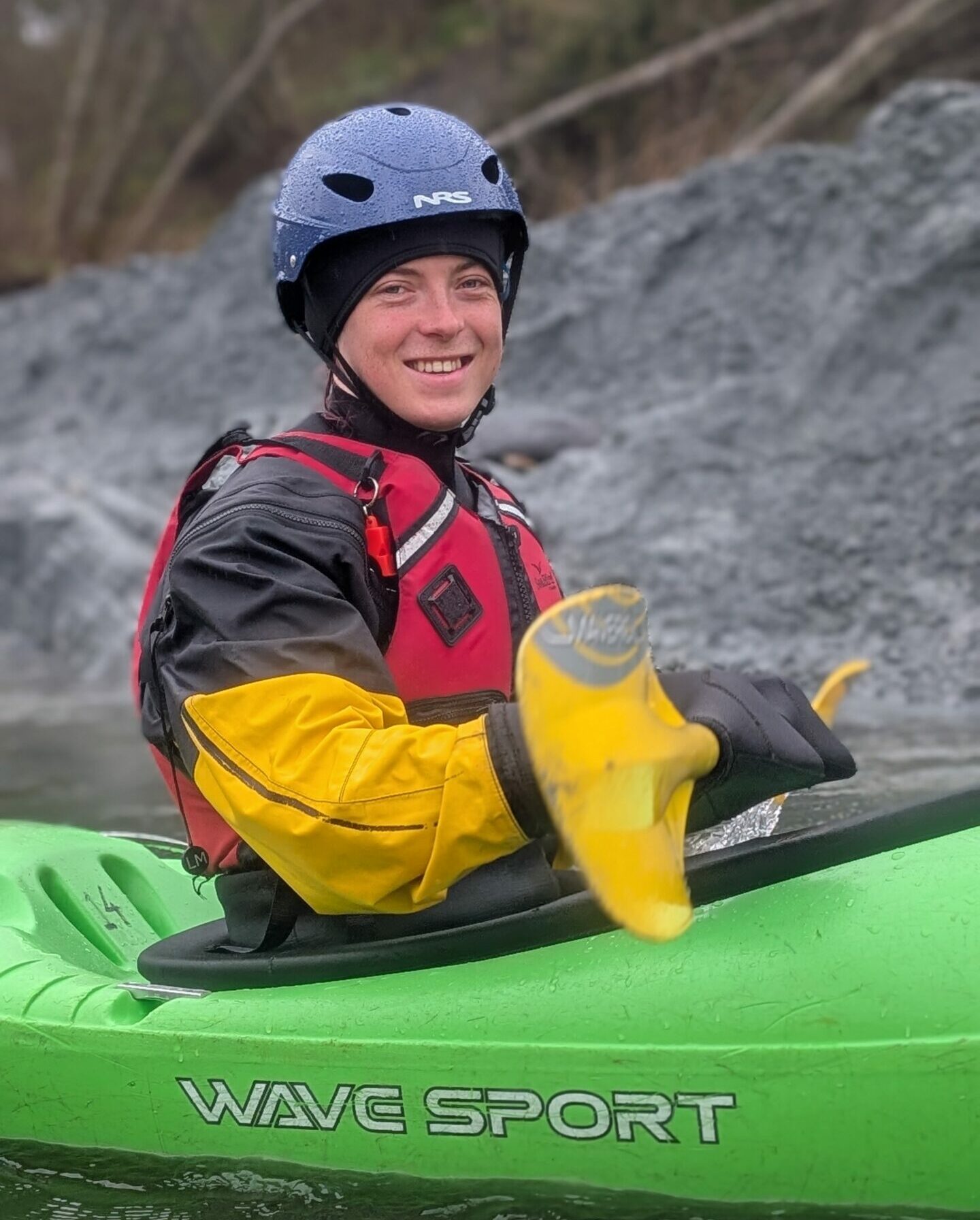 En gutt sitter i en kajakk med hjelm