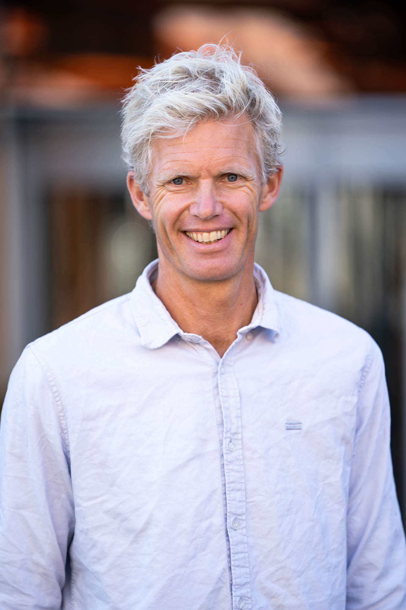 Lyshåret mann smiler i kamera