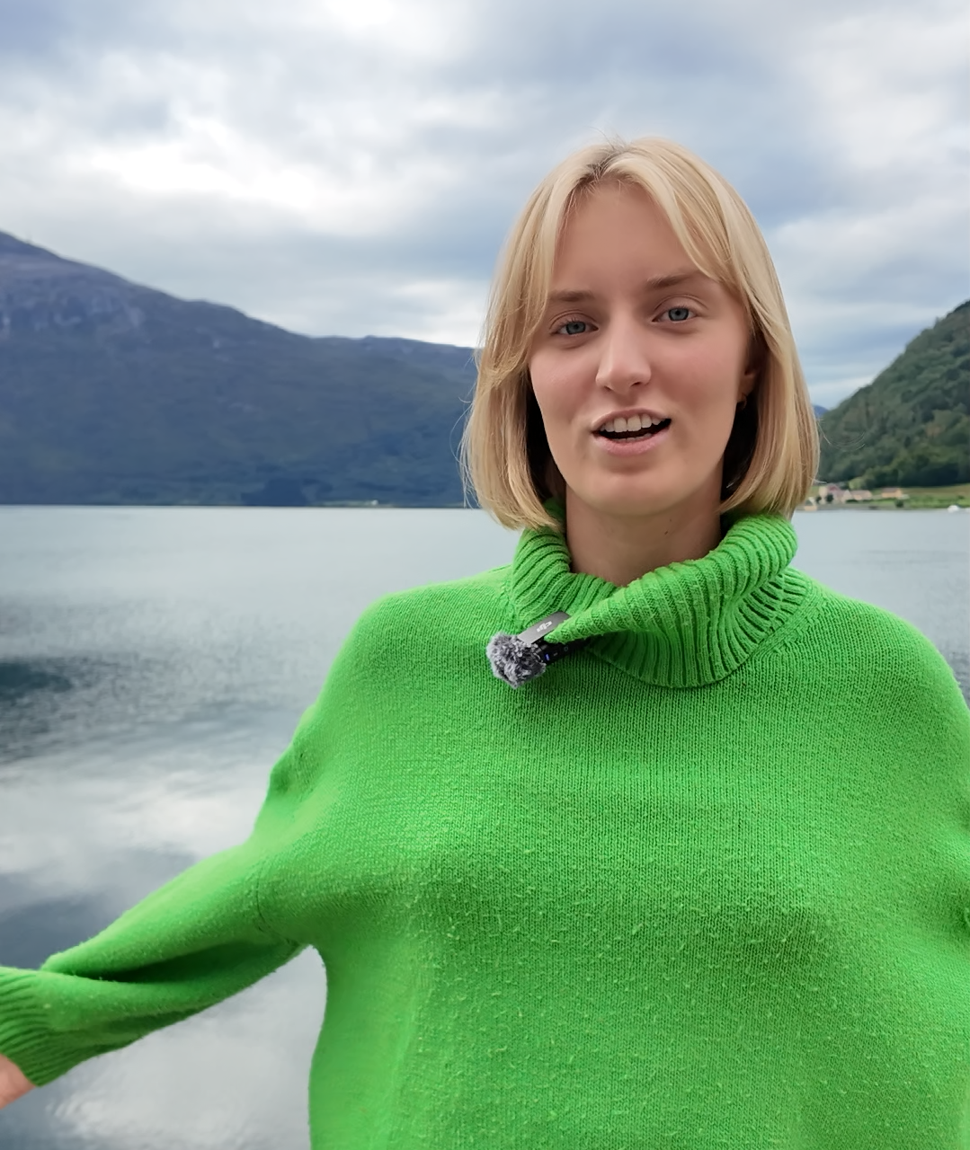 Jente i grønn genser foran fjord. Ulik alder.